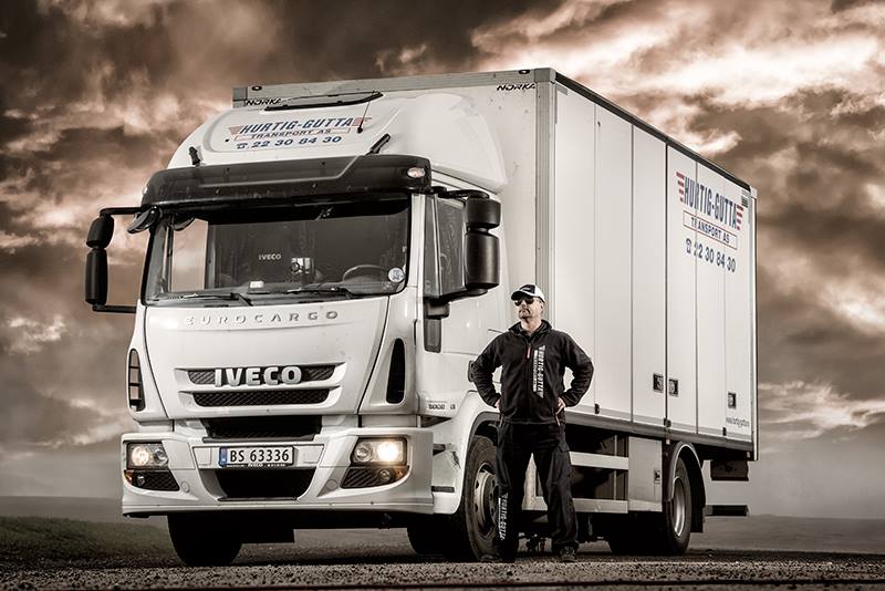 En ansatt ved Hurtig Gutta Transport AS poserer foran en bil, klar til å utføre transporttjenester i Oslo