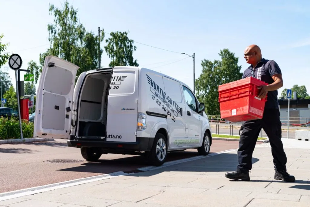 En ansatt og budbil ved Hurtig Gutta Transport AS, et transportselskap i Norge